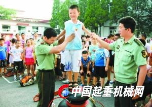 一位小學生正在警營體驗消防設施“起重氣墊”。昨日，懷柔區(qū)龍山街道60名中小學生走進武警懷柔消防中隊，近距離體驗消防裝備、學習消防知識，豐富暑期生活。